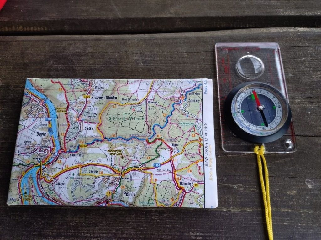 Mapa a buzola na stole - příprava na cestu